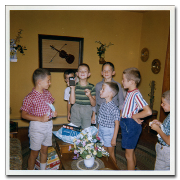 Larry Lachance with friends at 9th birthday, holding transistor radio
