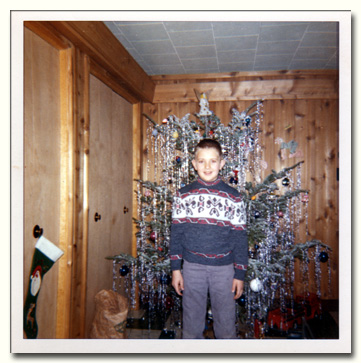 Larry Lachance in front of decorated Christmas tree in 1962